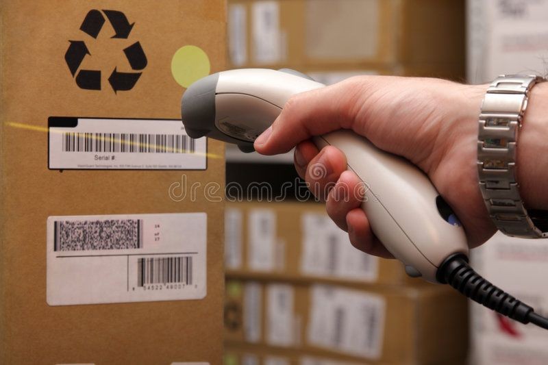 A hand holding a barcode scanner pointing at a product barcode