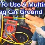 Testing car ground connection with a multimeter to diagnose why car won't start after scanner tool use.